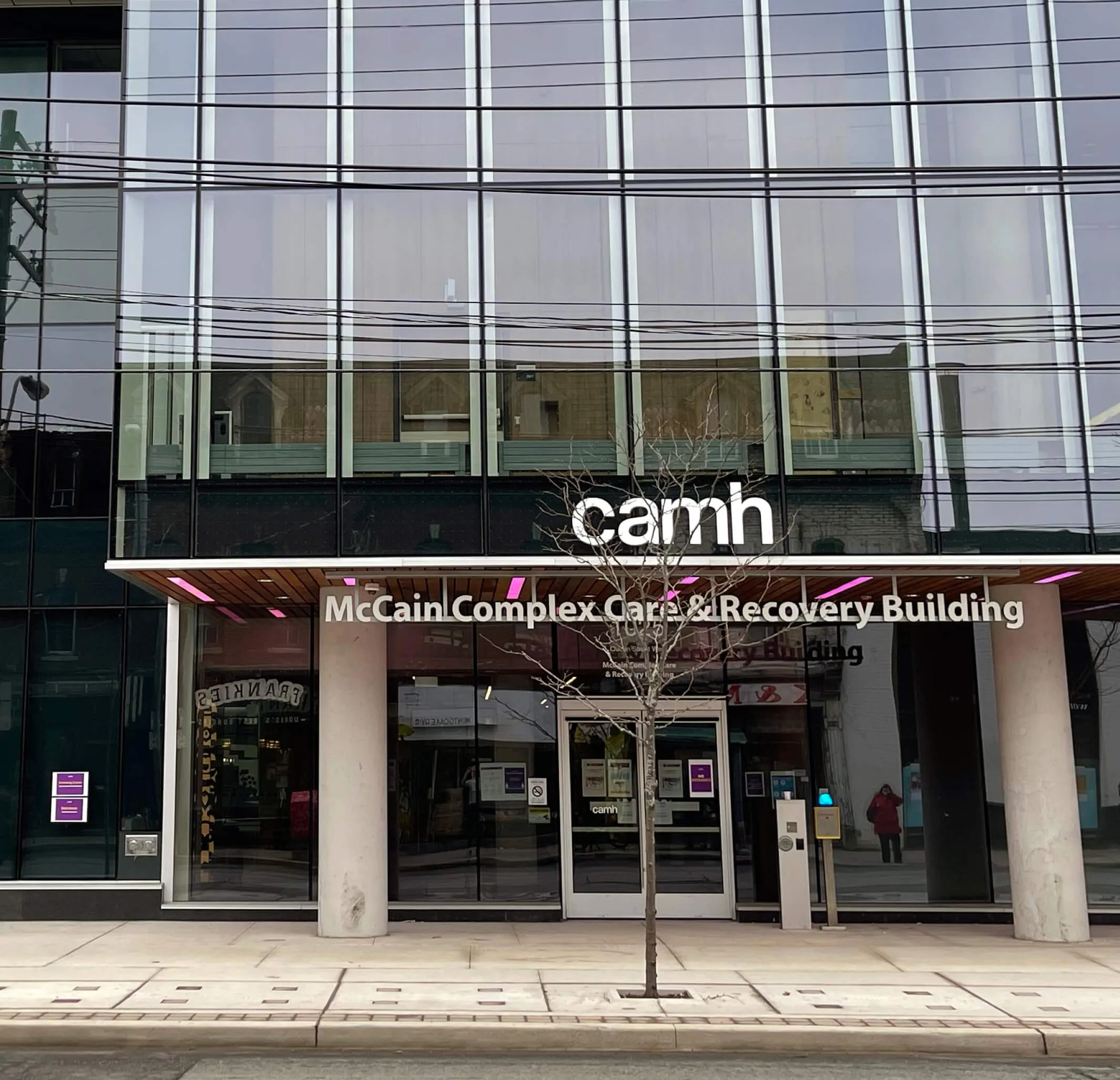 CAMH McCain Complex Care & Recovery Building entrance with a bare tree in front.
