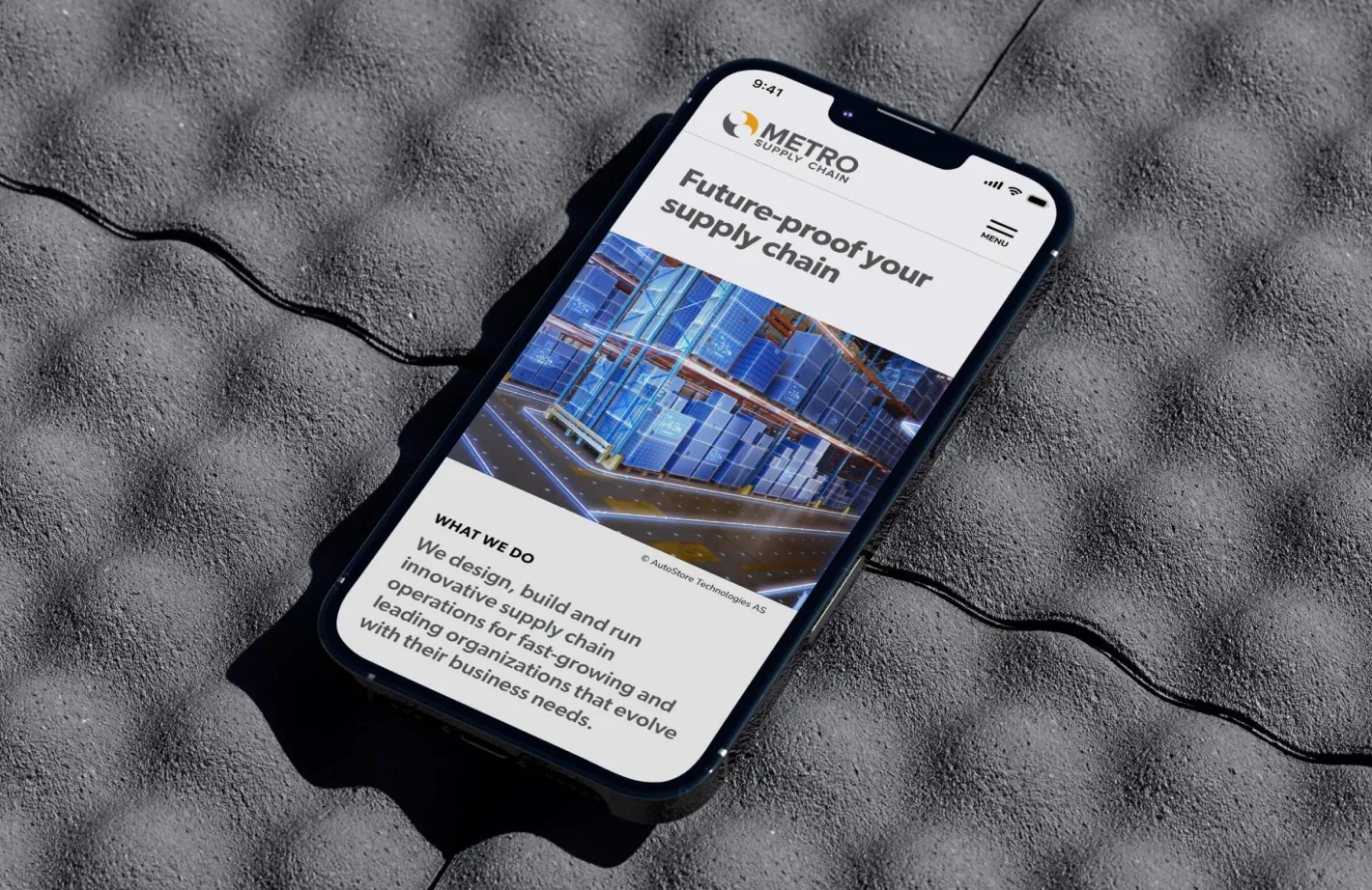 Metro Supply Chain website on a smartphone, showing a warehouse graphic and text.