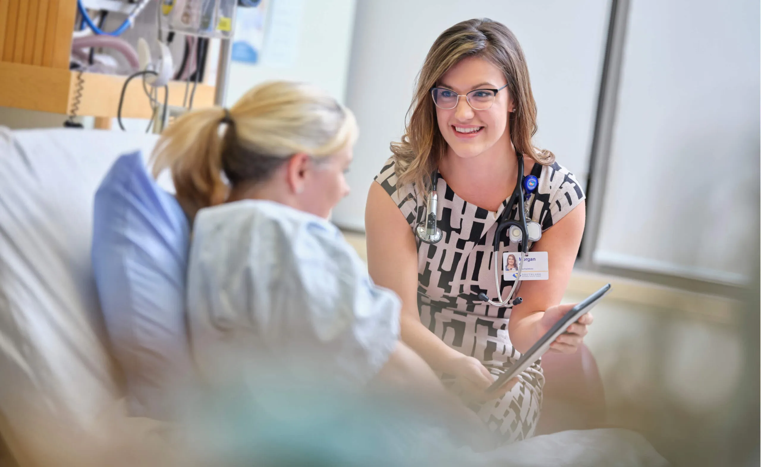 Doctor talking to patient in hospital room.