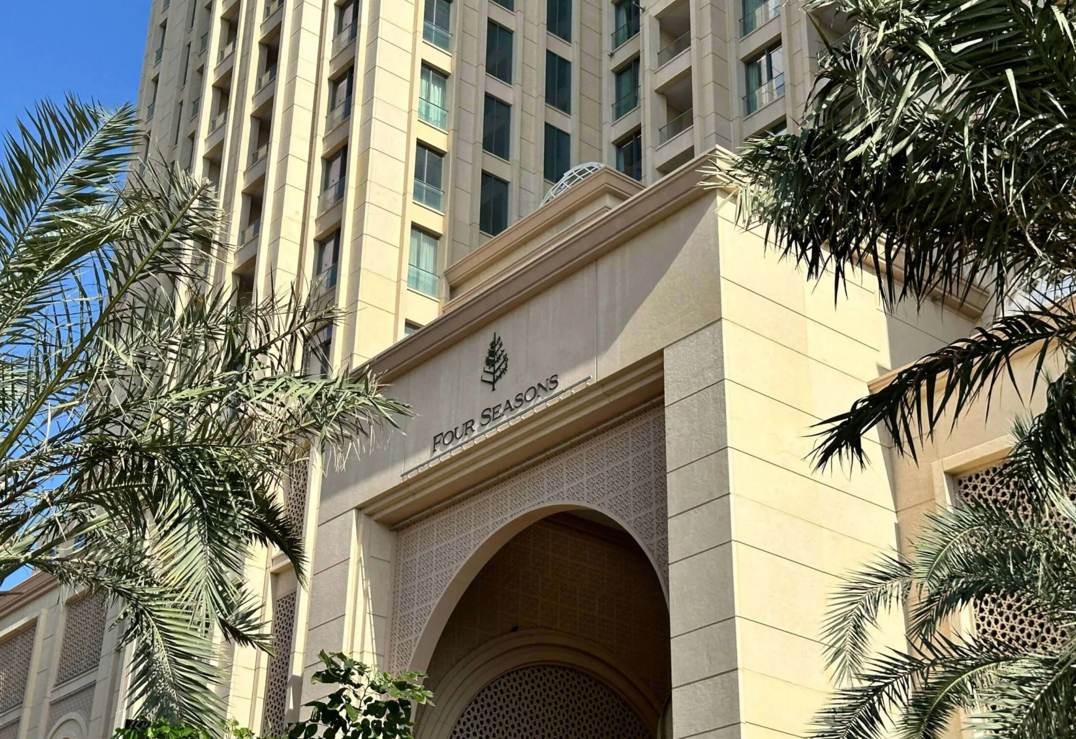 Four Seasons Hotel Doha entrance with palm trees.