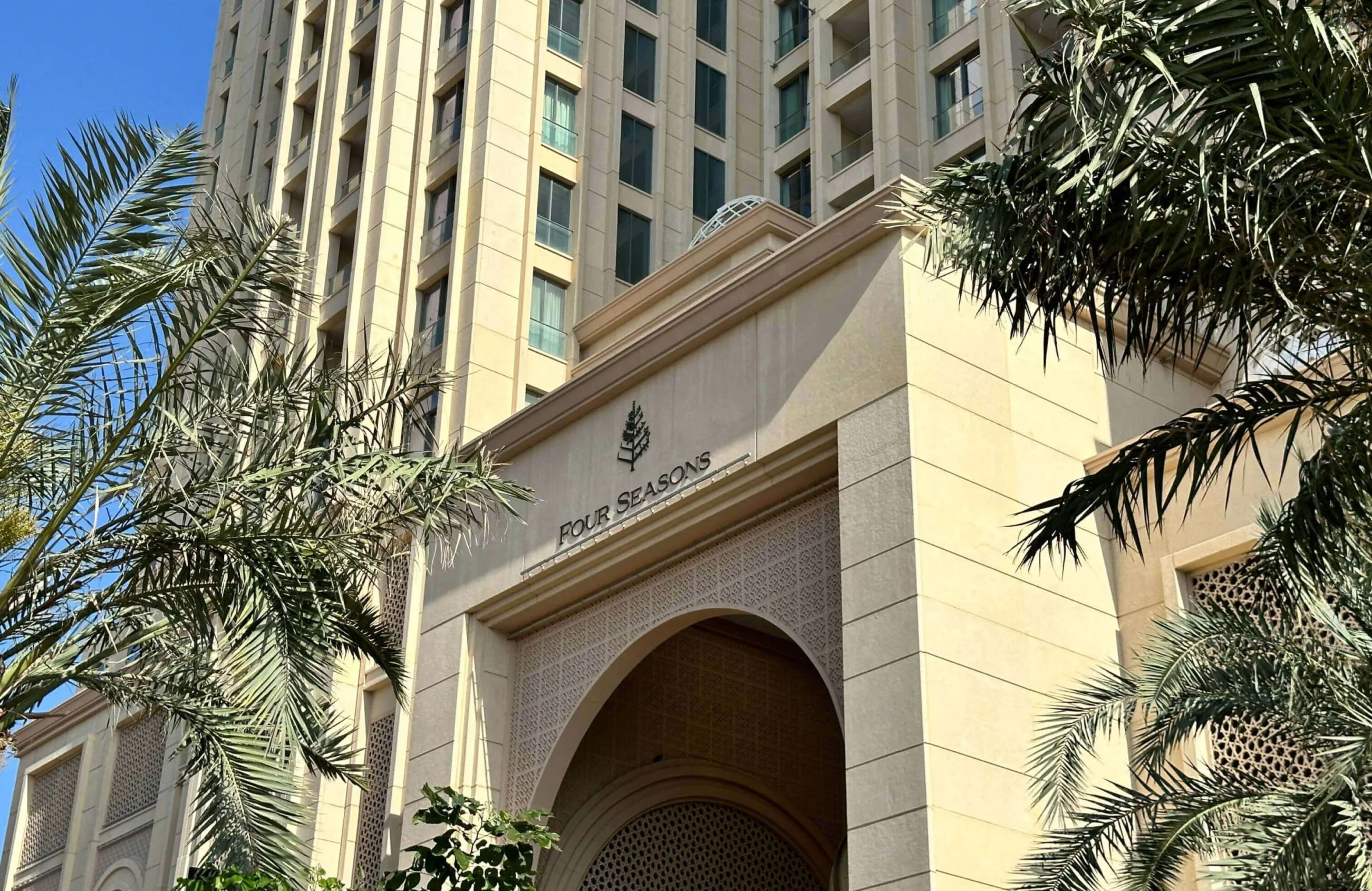 Four Seasons Hotel Doha entrance with palm trees.