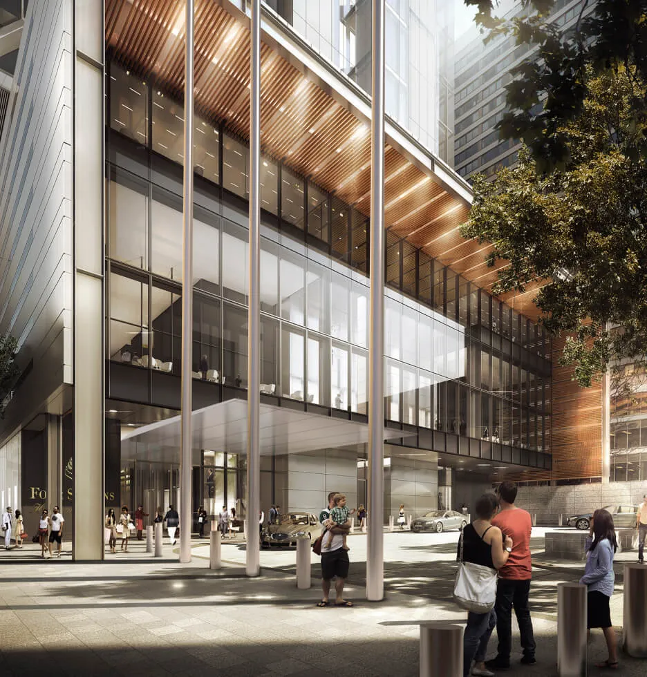 Modern glass building entrance with people and trees.