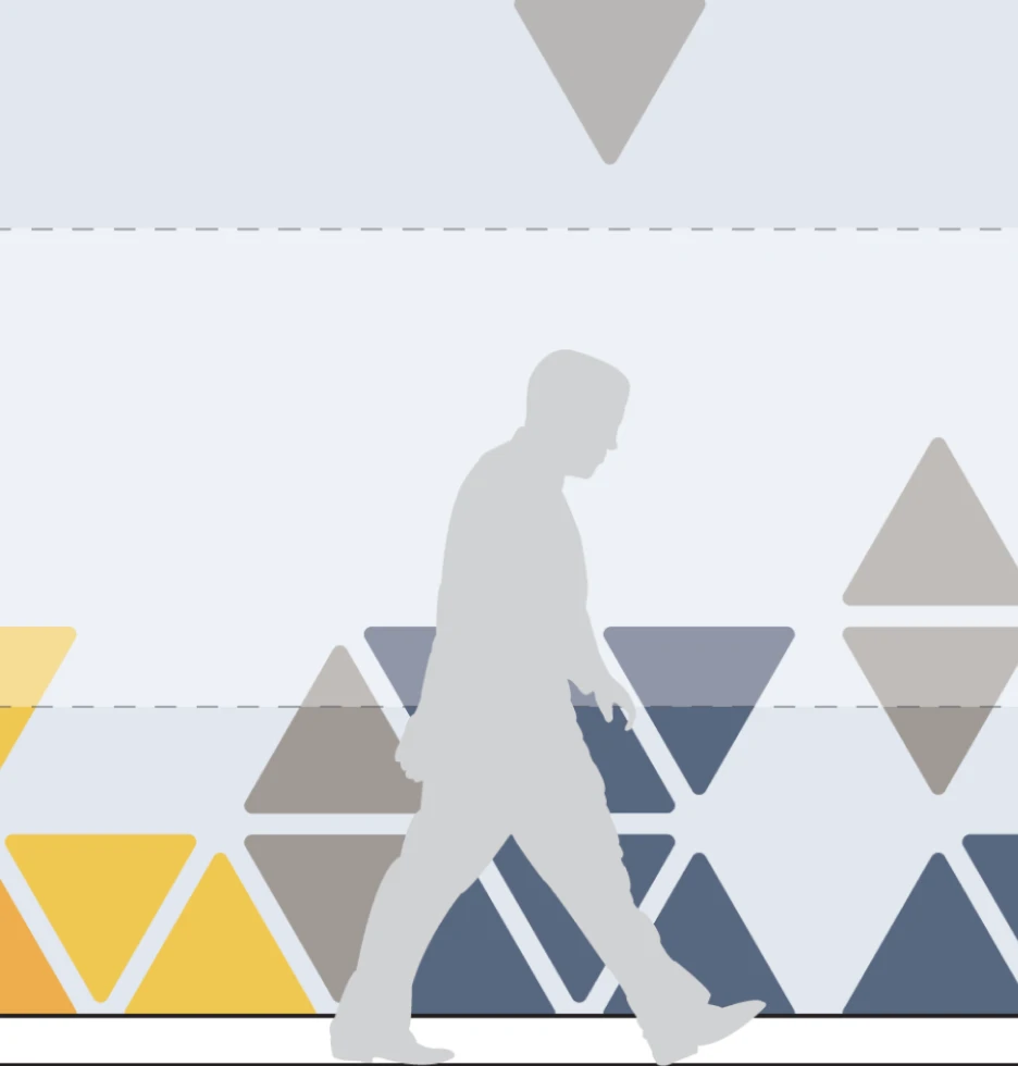 Silhouette of a person walking past a pattern of triangles in yellow, grey and blue.