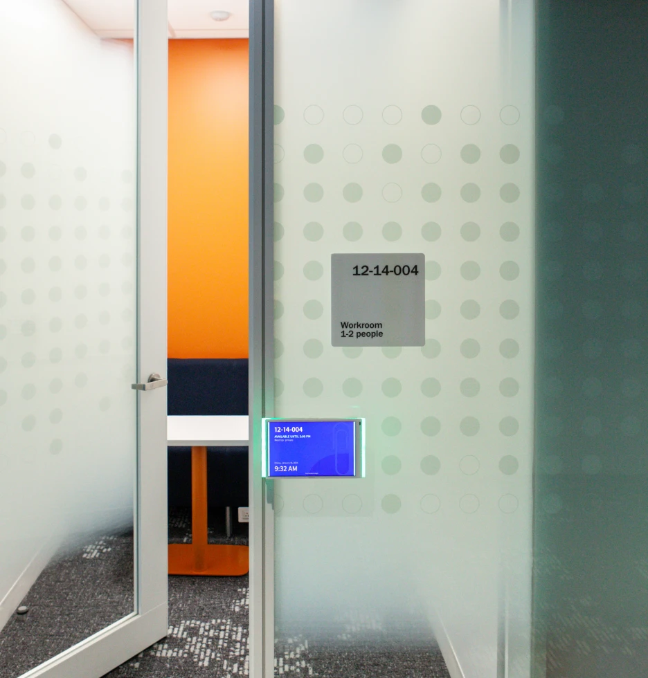 Door to a workroom with a digital display showing room availability.