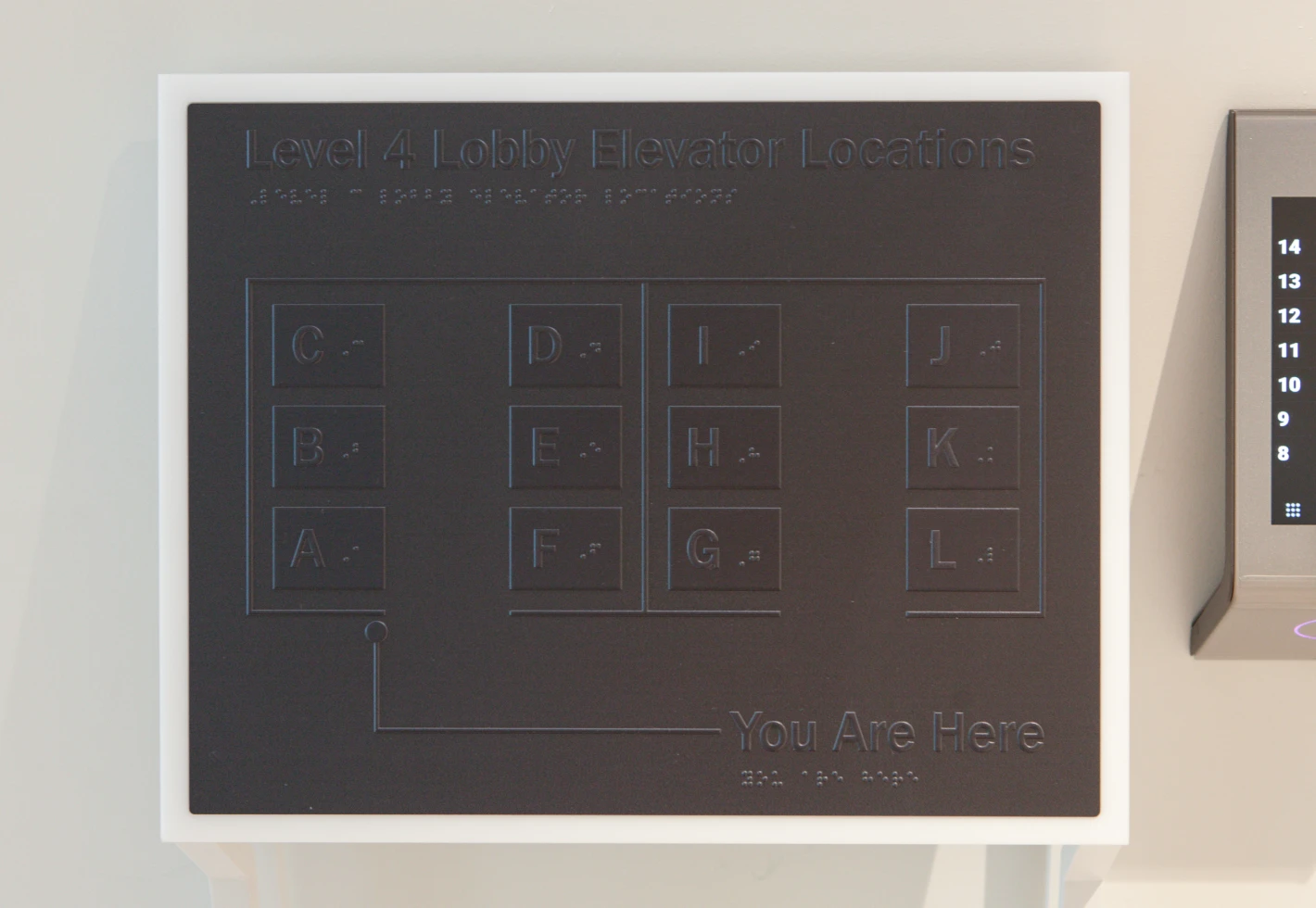Braille and raised letter directory for Level 4 Lobby elevator locations.